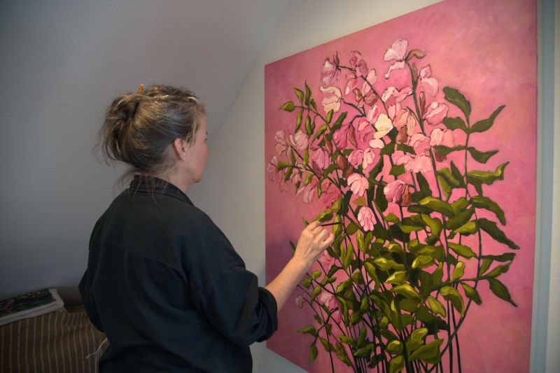 Margot Ressel demonstriert, wie sie die Pinsel ihres Vaters für das Blumengemälde Zartrosa Blüten eingesetzt hat. Foto: art24.